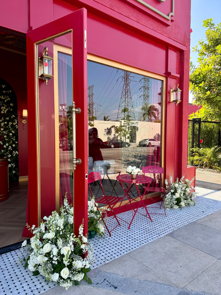 Burbank North Hollywood studio, European red building, with a red cafe table and chairs outside and white flowers