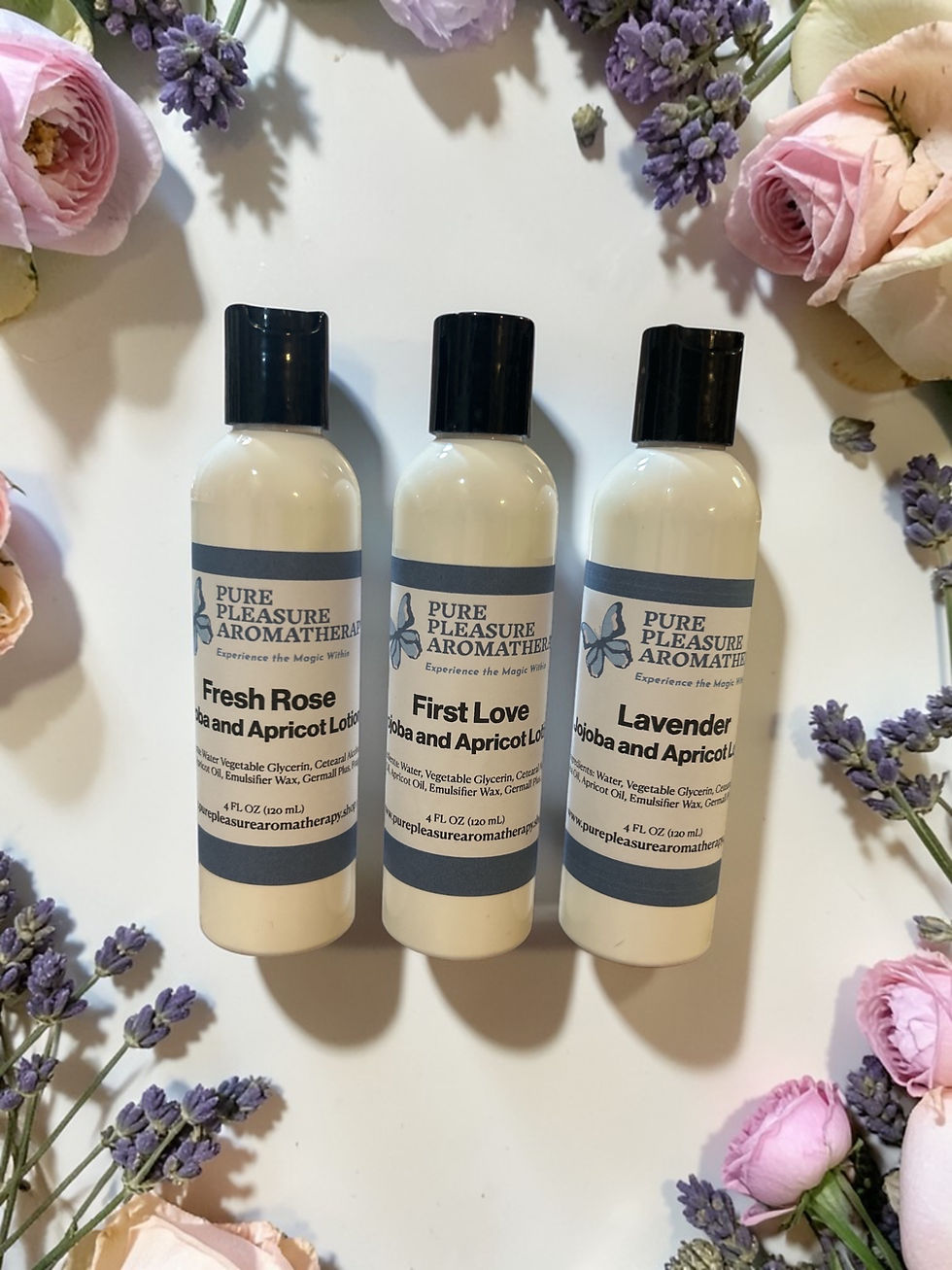 3 bottles of lotion surrounded by flowers