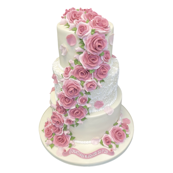 Three-tier wedding cake with pink sugar paste roses cascading elegantly down the sides.