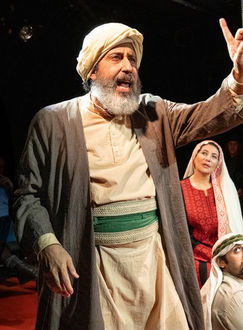 A Palestinian man gestures while explaining as a Jewish man and woman and Palestinian woman and man look on.