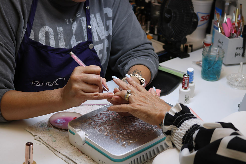 Nail technician applying polish to a client's hand