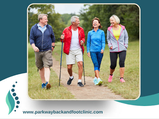 Parkway Back and Foot Clinic branded image with a picture of four friends out for a pain-free walk in the summer along a path in the park.