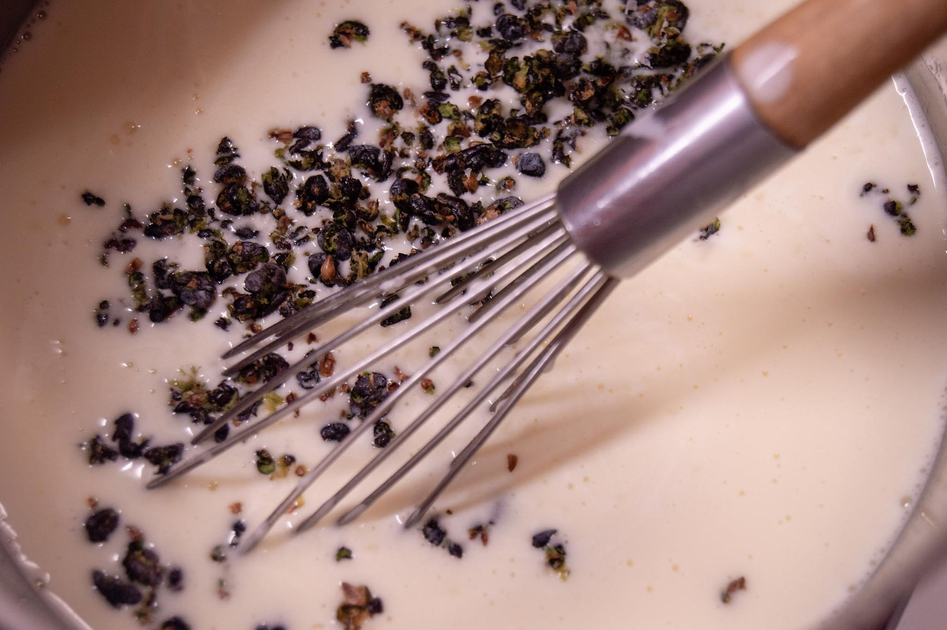 Mixing the juniper berries in the cream. These will later be strained out. 