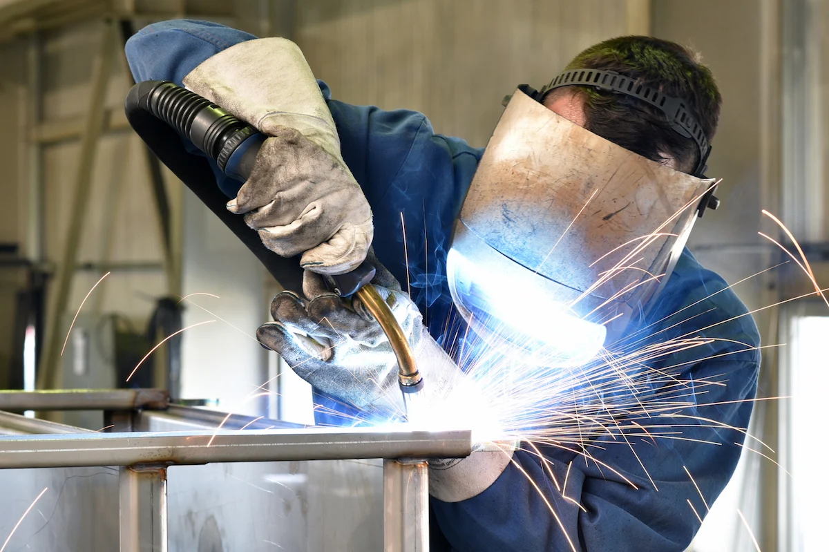 Welder performing metal fabrication work in a workshop