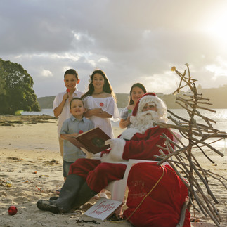 two girls and two boys on the beach with Santa