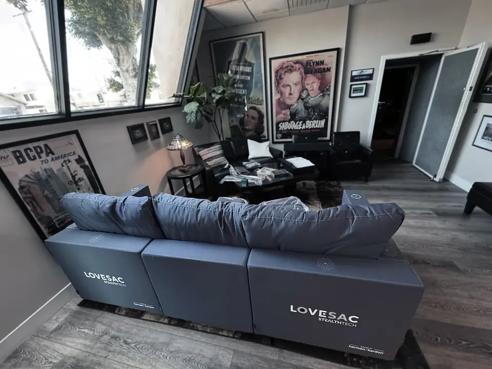 Gray Lovesac couch in a demo room with movie posters all around, Lovesac StealthTech demo at Smart Post Sound in Burbank.
