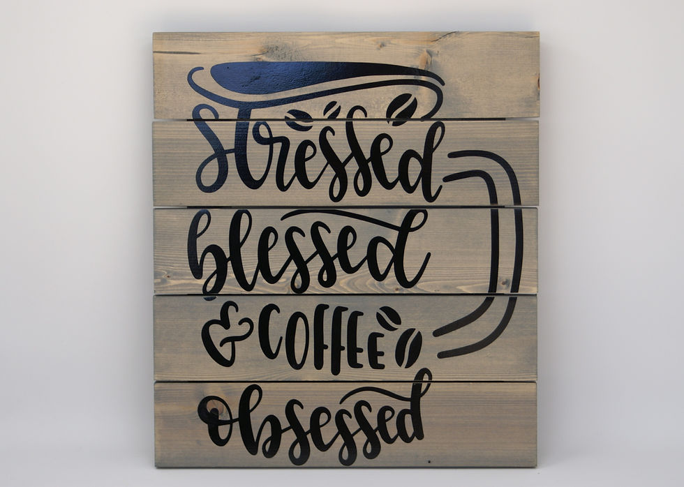 Gray wood plank sign with black words reading Stressed, Blessed, and Coffee Obsessed. Words are the shape of a coffee mug