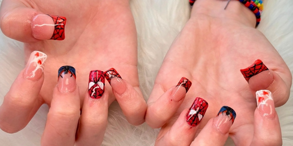 Two hands with long Spider-Man-inspired red, blue and white web nail art displayed over a white furry background.