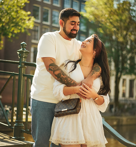 A couple hug each other while taking romantic pictures on the stairs. 