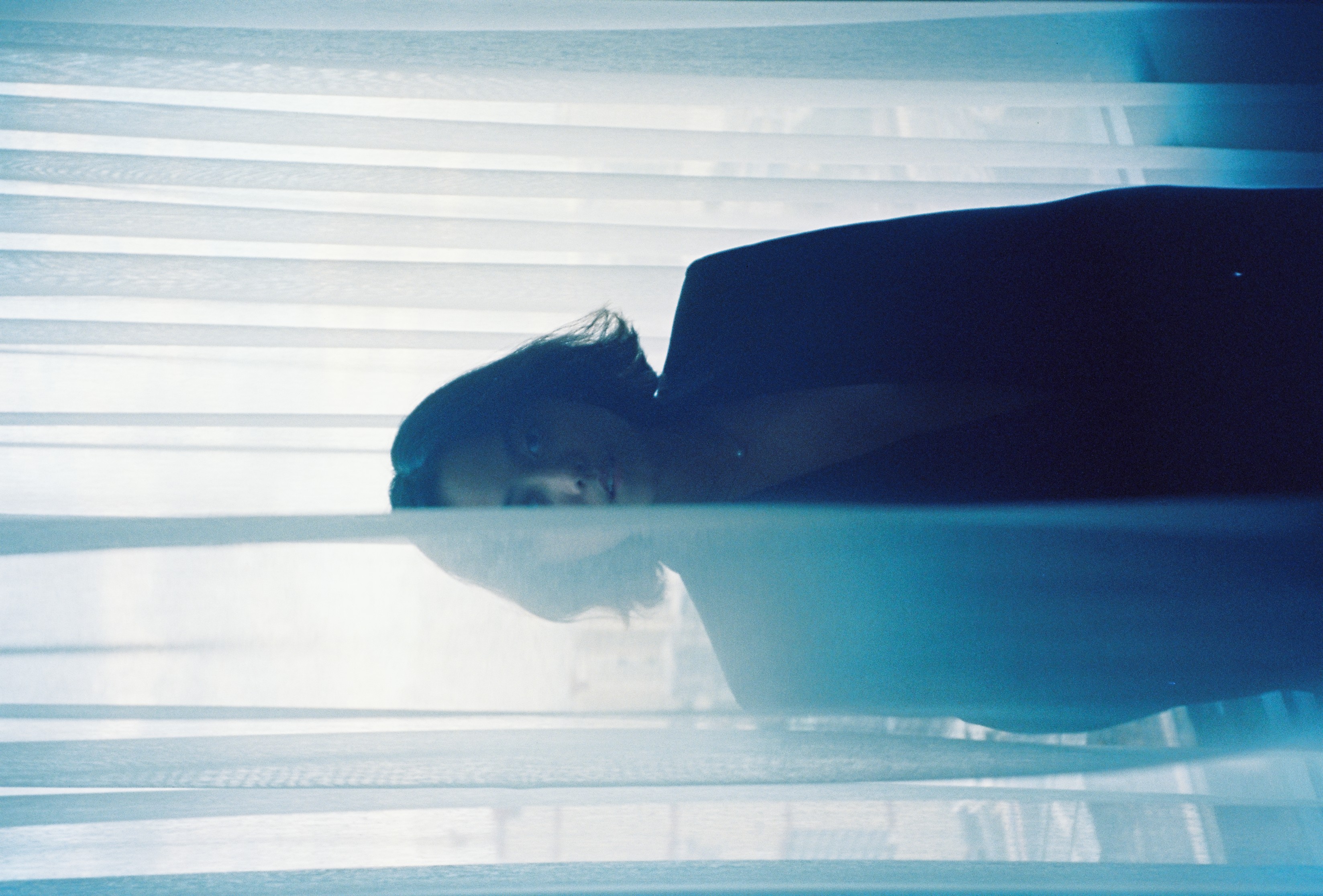 a film photograph of a girl by the window
