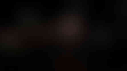 Man with glasses, durag, and camera strap at night