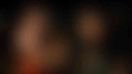 Smiling woman in '15' top waving, next to another woman