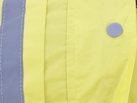 Reflective stripe and snap closure on the yellow Puget Sound Rain Slicker