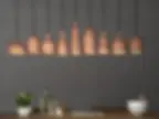 Thumbnail: Groupie terracotta ceramic pendant lights clustered together in a dark interior