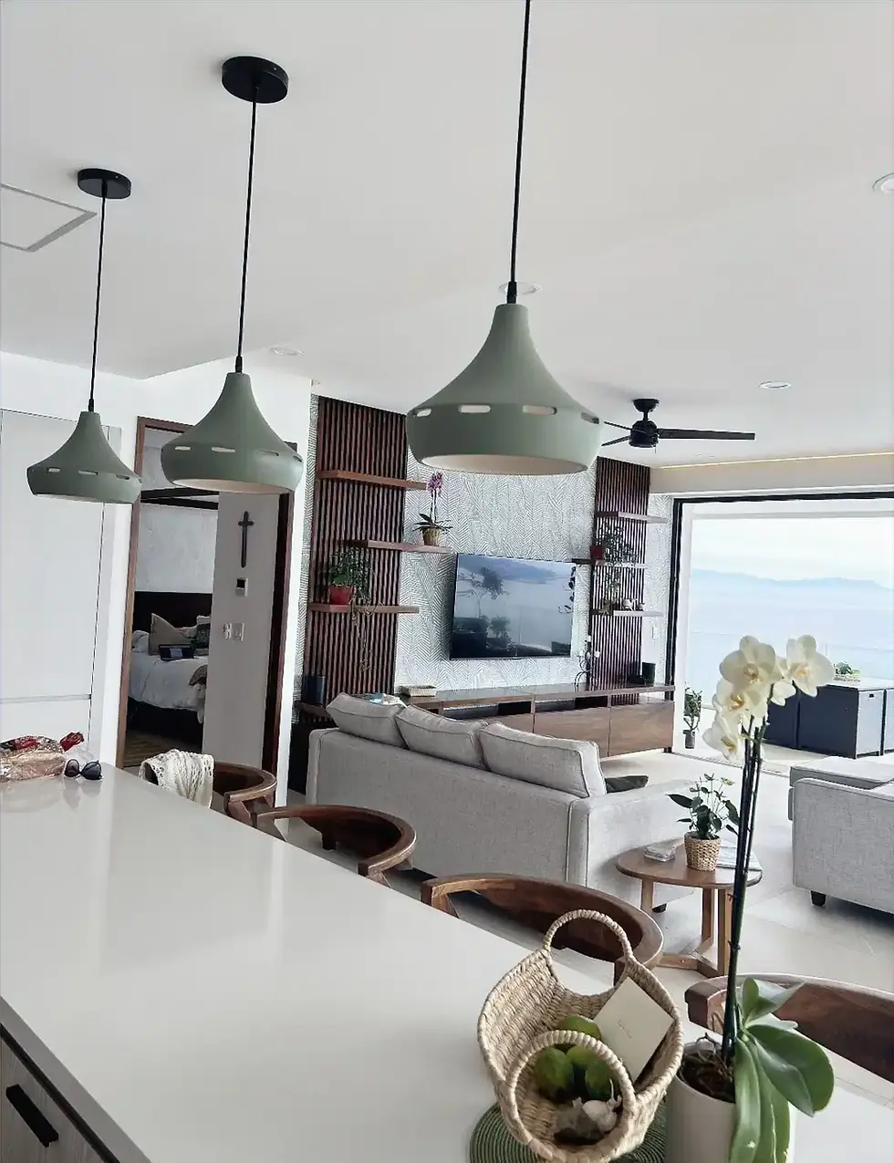 Thumbnail: Set of 3 Rosemary Farmhouse ceramic wide pendant lights hanging over kitchen island near a living room near shelving