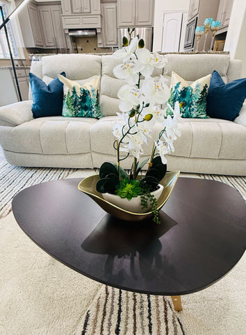 Neutral sectional with blue throw pillows and floral centerpiece