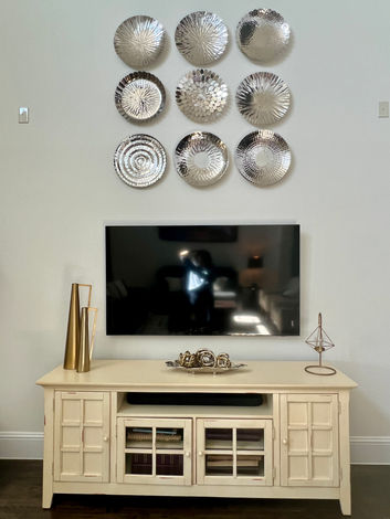 Elegant modern living and dining room with neutral tones, wall decor, and gold chandelier by CoziZone Interior Design.