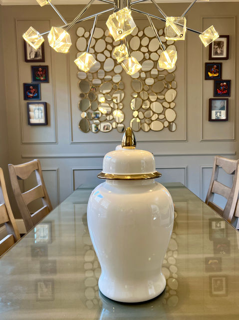 Elegant modern living and dining room with neutral tones, wall decor, and gold chandelier by CoziZone Interior Design.