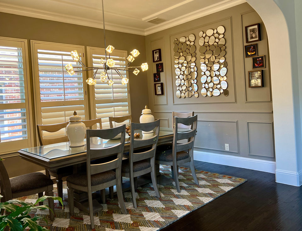 Elegant modern living and dining room with neutral tones, wall decor, and gold chandelier by CoziZone Interior Design.