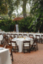 Outdoor wedding coordination services featuring formal table setups and wooden chairs.