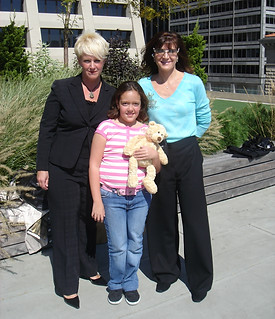 Two women posing with teenage girl in front of a building