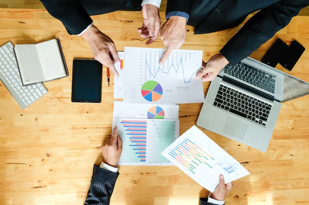 equipo-negocios-trabajando-nuevo-plan-negocios-computadora-digital-moderna-disparo-vista-s