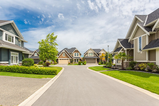 Nicely trimmed and manicured garden in front of a luxury house on a sunny summer day. Stre