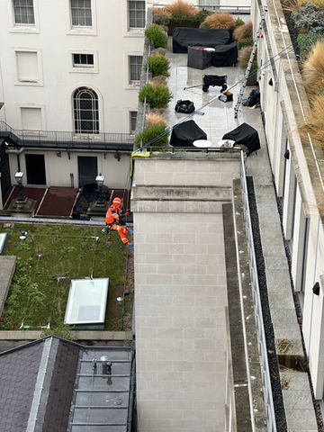 Art of Alpine rope access technician performing building maintenance