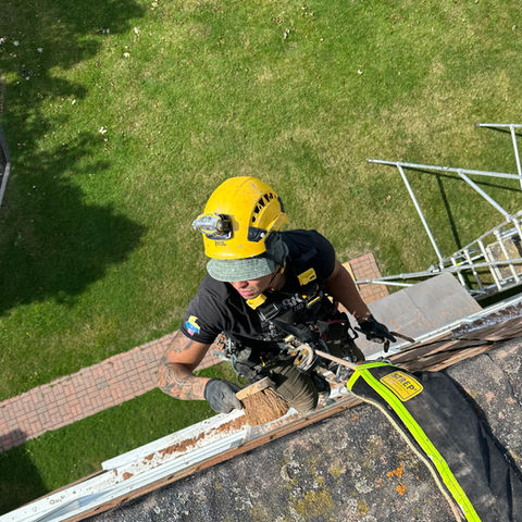 Art of Alpine rope access technician performing building maintenance