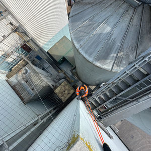 Art of Alpine rope access technician performing building maintenance