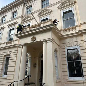 Art of Alpine rope access technician performing building maintenance