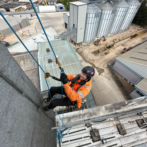 Art of Alpine rope access technician performing building maintenance