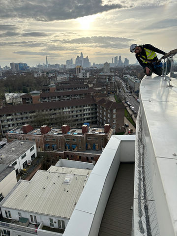 Art of Alpine rope access technician performing building maintenance