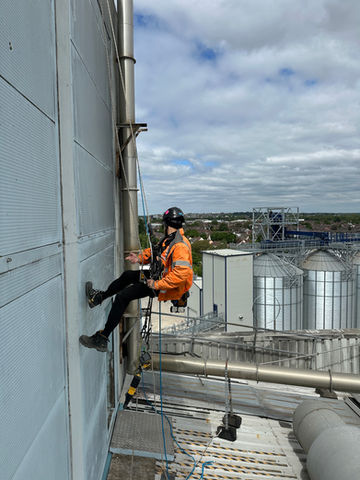 Art of Alpine rope access technician performing building maintenance
