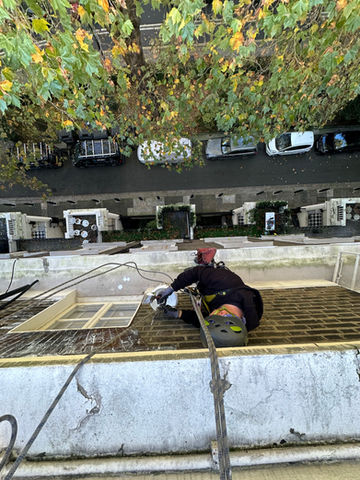 Art of Alpine rope access technician performing building maintenance