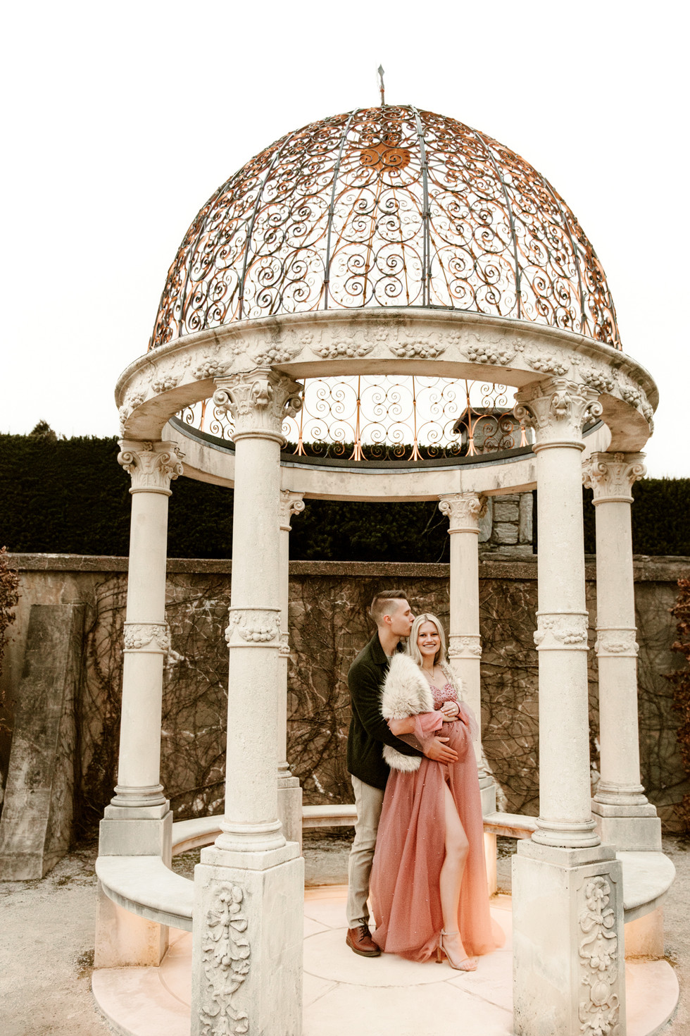 elegant couple in garden for Christmas maternity pictures