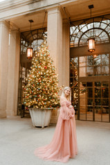 elegant woman in garden for maternity pictures