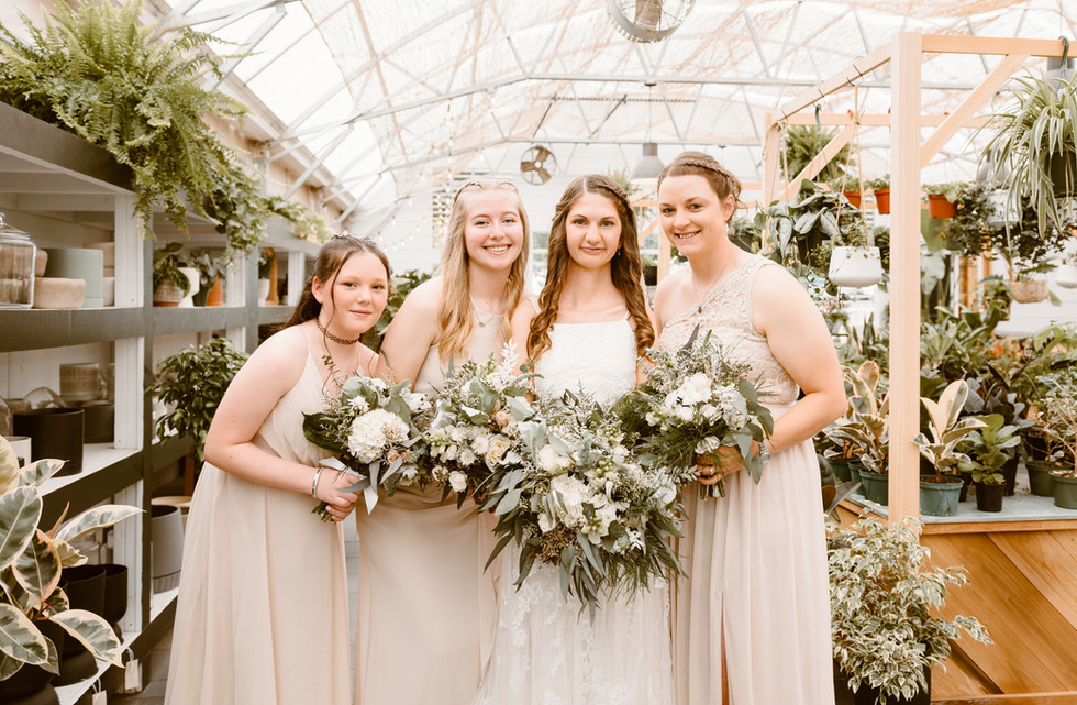 bride and bridesmaids in greenhouse for wedding