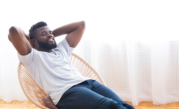young-african-guy-relaxing-at-home-resting-on-cha-2021-08-30-02-27-08-utc.jpeg