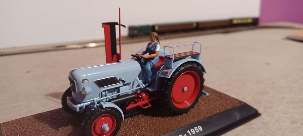Thumbnail: FIG 107: O Gauge hand painted figure, female driving a tractor arms raised.
