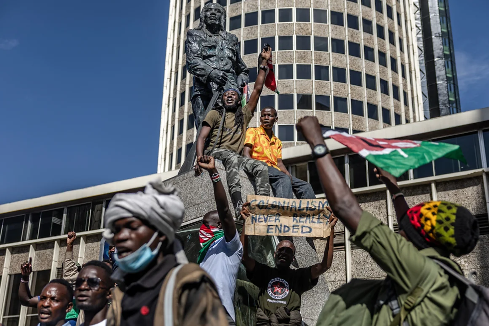 Protesters chant slogans surrounding the statue of Kenyan leader against the British colonial rule, Dedan Kimathi, as they march demanding the resignation of senior officers. Luis Tato/AFP via Getty Images
