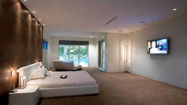 Spacious bedroom suite with integrated entertainment area at Portrush House