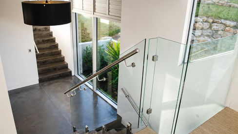 Internal staircase with glass balustrade and large windows at Mulgoa House