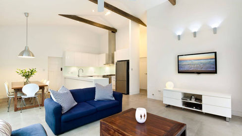 Open-plan living and dining area with exposed timber beams at Creewood House