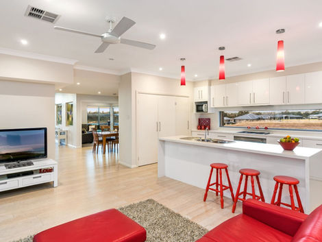 Medinah House Custom New Home Design by Distinct Innovations Contemporary New Home white kitchen oak timber floors red lounge red bar stools