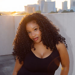 Woman with curly hair posing at sunset for photography booking
