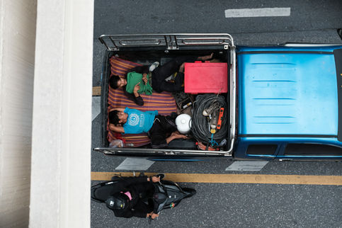 looking down on 2 workers in the back of a truck in Bangkok, Thailand
