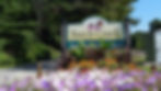 Welcome sign with Beech Creek written on it with artwork of pink flowers and a butterfly.