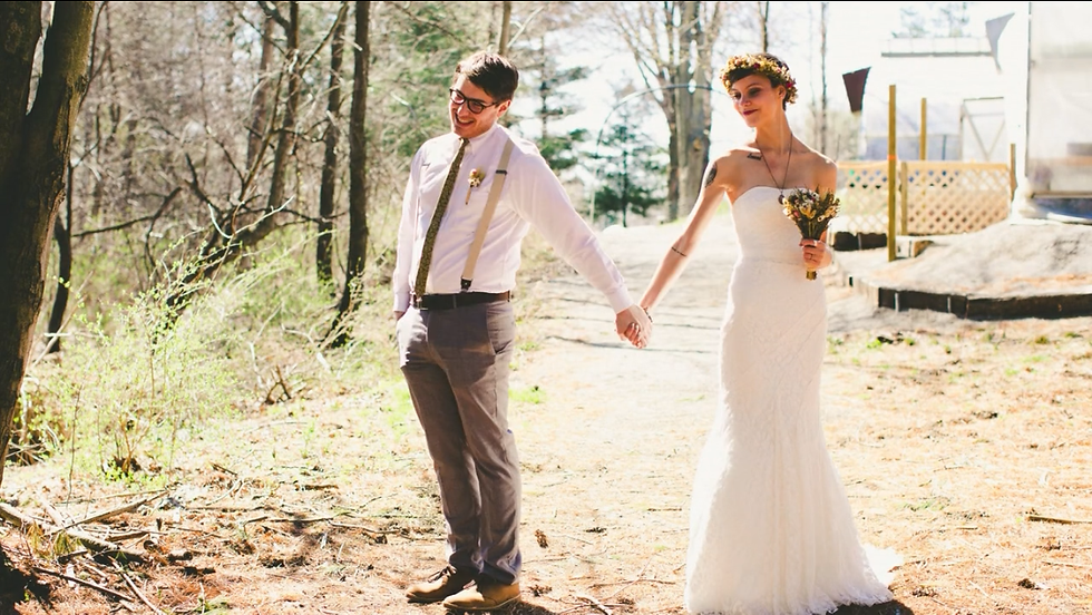Newlyweds, a man and a women, holding hands on a trail.