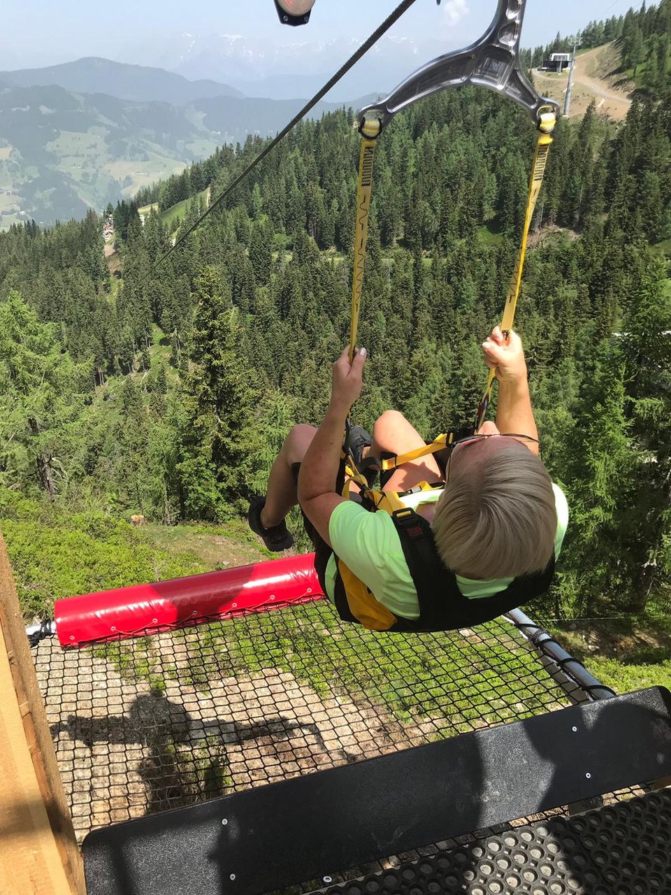 Frau nutzt den Almrausch Flieger (Flying Fox) vom Wagrainer Haus zum Almstadl